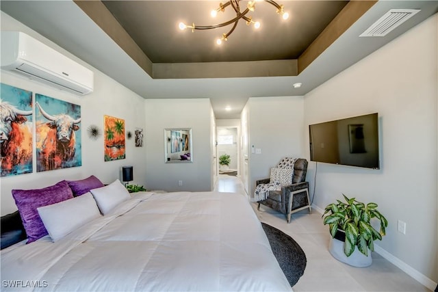 bedroom with a tray ceiling, a wall unit AC, and an inviting chandelier