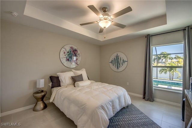 bedroom with ceiling fan and a tray ceiling