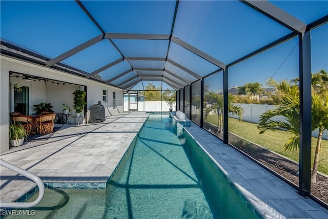 view of swimming pool featuring glass enclosure, an outdoor bar, and a patio area