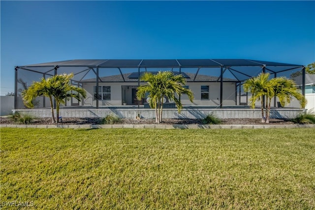 back of house featuring a lanai and a yard