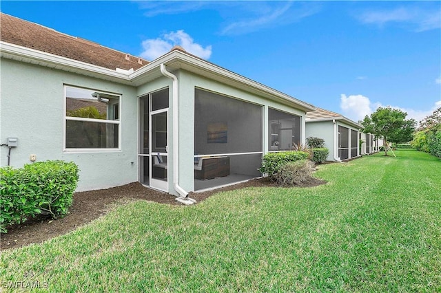 view of side of property featuring a sunroom and a lawn