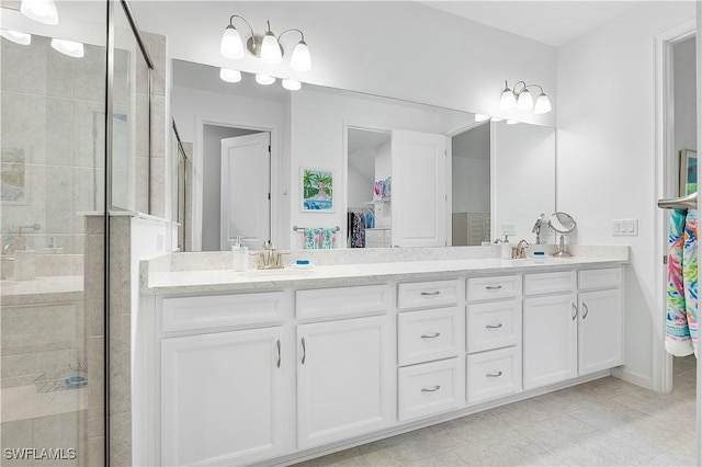 bathroom with tile patterned flooring, walk in shower, and vanity