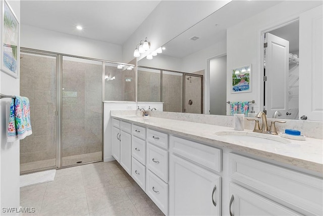 bathroom with a shower with door, tile patterned floors, and vanity