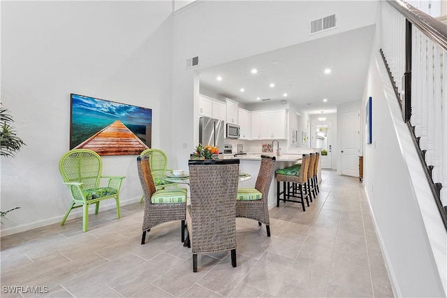 dining space featuring a high ceiling and sink