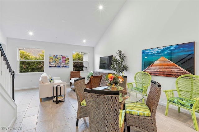 tiled living room with plenty of natural light and high vaulted ceiling