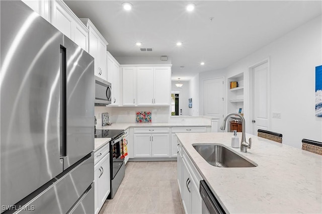 kitchen featuring light stone countertops, white cabinets, built in shelves, stainless steel appliances, and sink