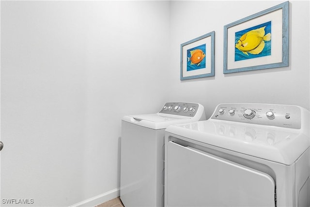 clothes washing area featuring light tile patterned flooring and washing machine and clothes dryer