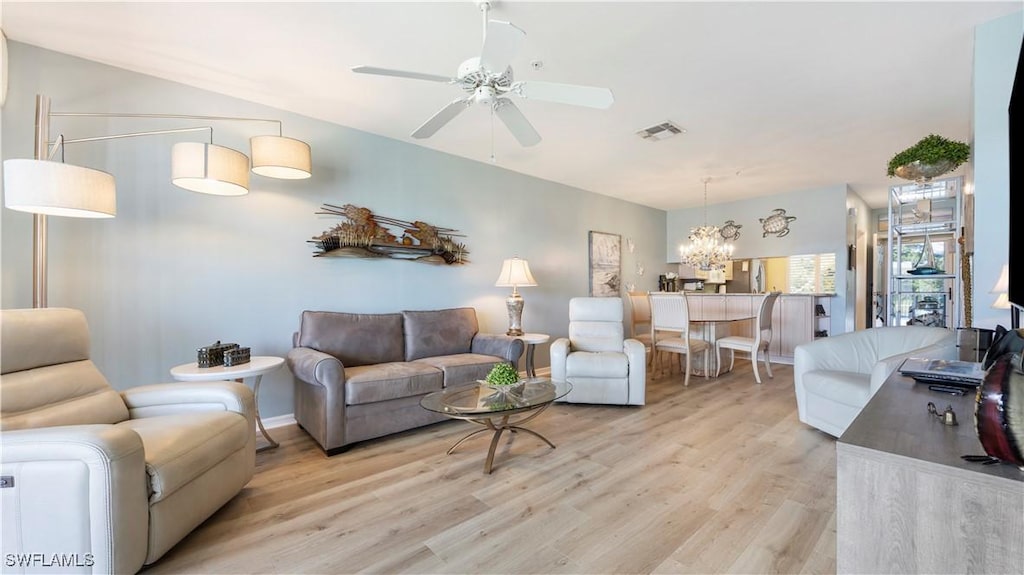 living room featuring light hardwood / wood-style floors and ceiling fan with notable chandelier