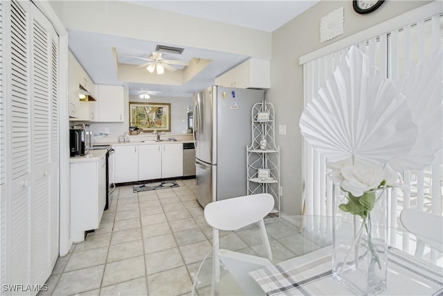 kitchen featuring sink, white cabinets, light tile patterned floors, ceiling fan, and stainless steel appliances