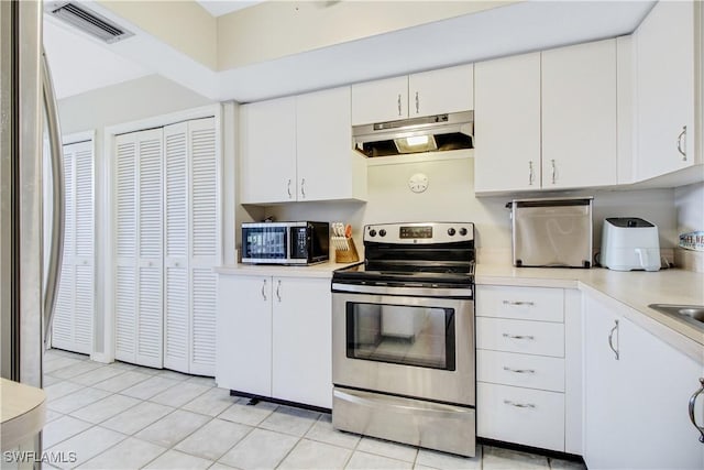 kitchen featuring white cabinetry, appliances with stainless steel finishes, and light tile patterned flooring