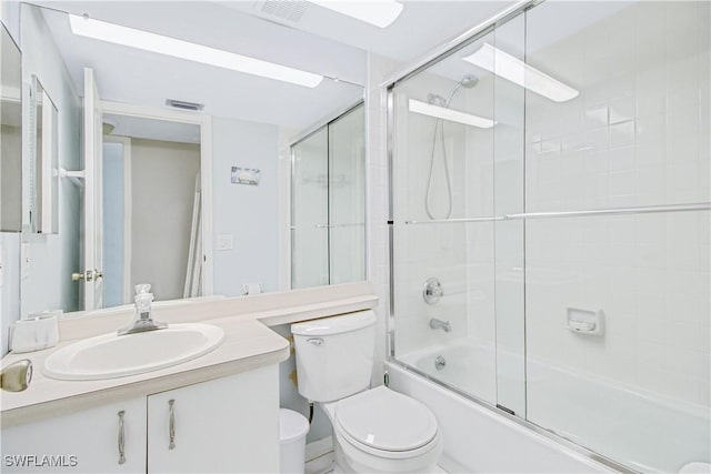 full bathroom featuring shower / bath combination with glass door, vanity, and toilet