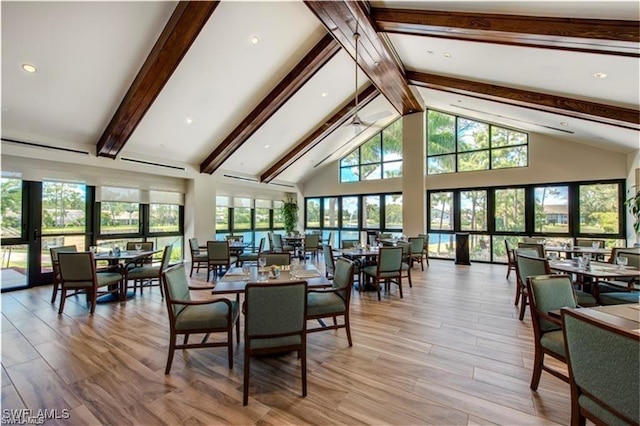 dining space with beamed ceiling, a healthy amount of sunlight, and high vaulted ceiling