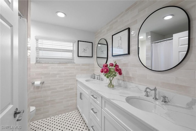 bathroom featuring toilet, vanity, tile walls, walk in shower, and tile patterned floors