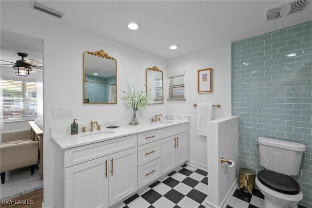 bathroom featuring ceiling fan, vanity, toilet, and walk in shower