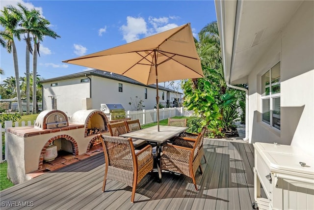 wooden deck with grilling area, exterior fireplace, and area for grilling