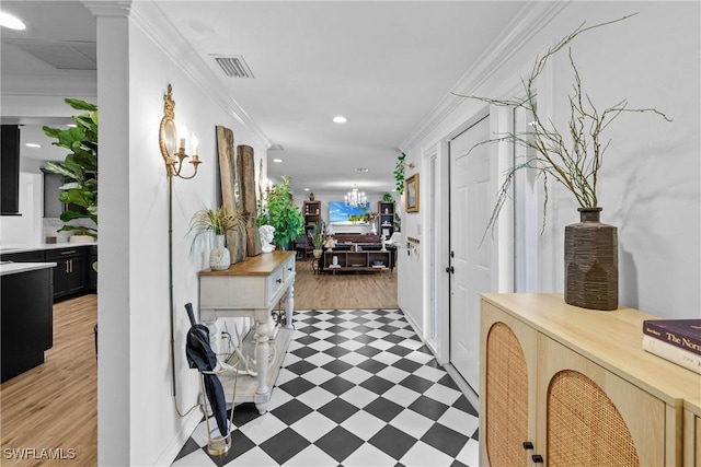 hall featuring ornamental molding and a notable chandelier