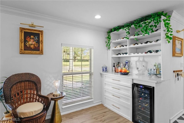 bar with white cabinets, crown molding, and wine cooler