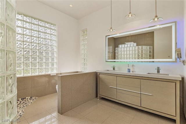 bathroom featuring a tile shower, tile patterned floors, and vanity