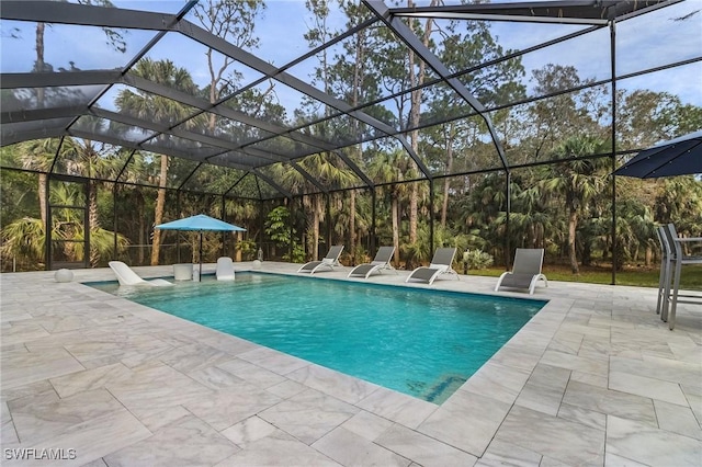 view of swimming pool with glass enclosure and a patio