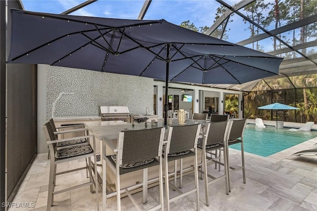 view of swimming pool featuring a lanai, an outdoor kitchen, area for grilling, exterior bar, and a patio area