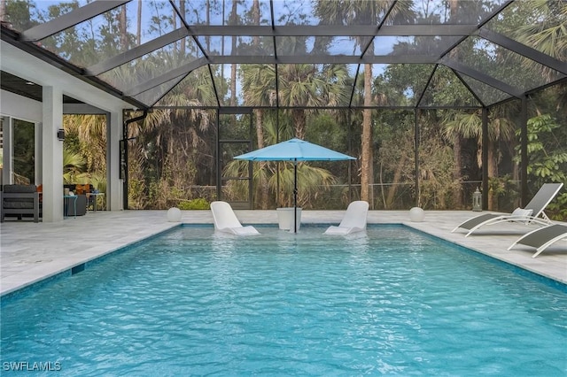 view of pool with glass enclosure and a patio area