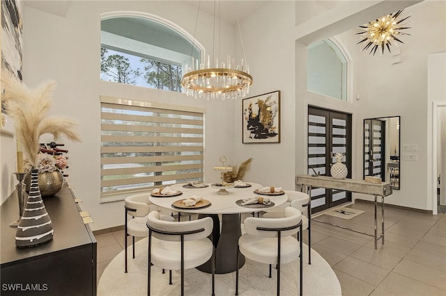 tiled dining room with a high ceiling and a notable chandelier