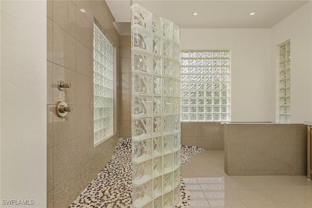 bathroom featuring a tile shower and tile patterned flooring