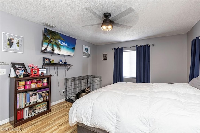 bedroom featuring hardwood / wood-style flooring, a textured ceiling, and ceiling fan