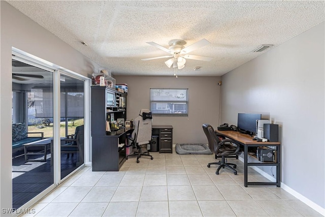 tiled office space with a textured ceiling and ceiling fan