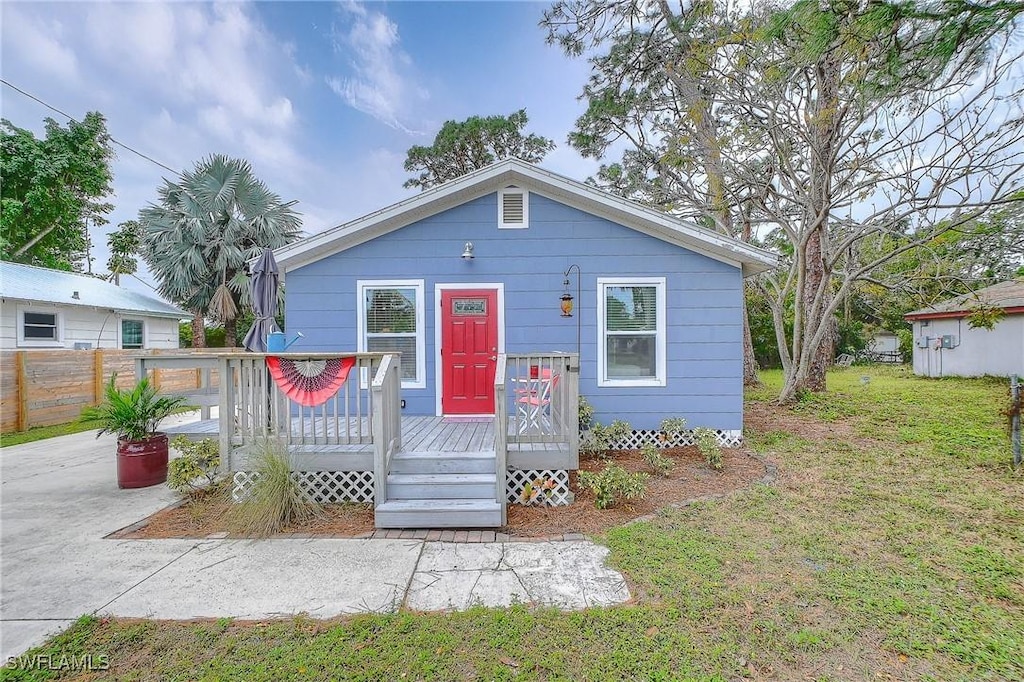 view of front of property with a wooden deck and a front lawn