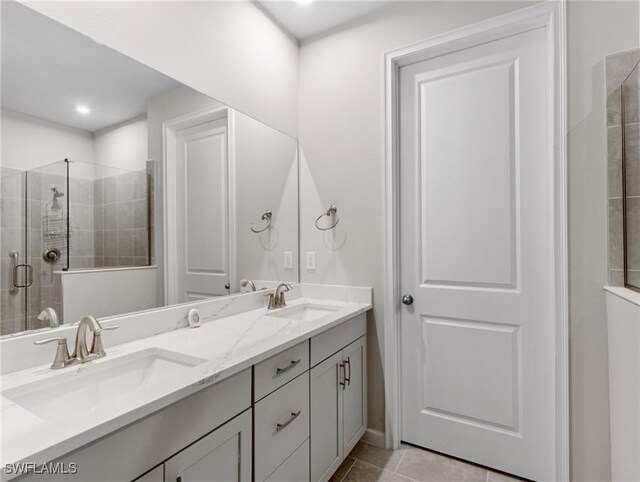 bathroom featuring tile patterned flooring, an enclosed shower, and vanity