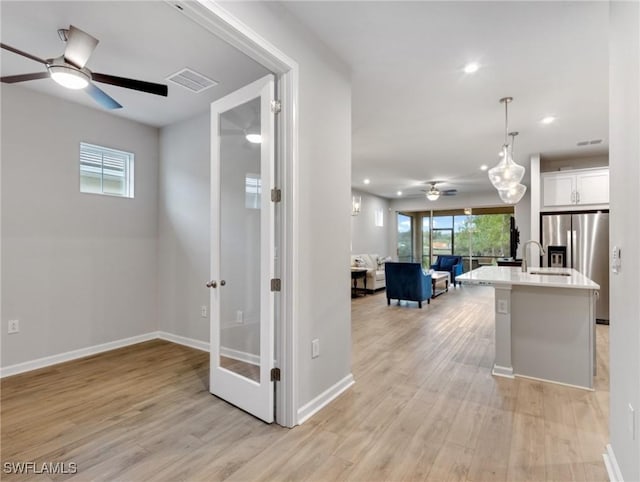 corridor with light wood-type flooring and french doors