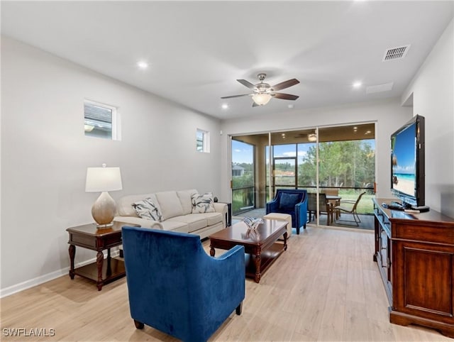 living room with light hardwood / wood-style floors and ceiling fan