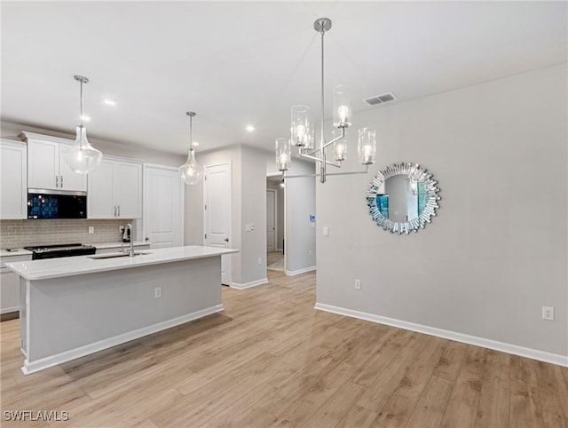 kitchen with sink, white cabinetry, pendant lighting, and tasteful backsplash