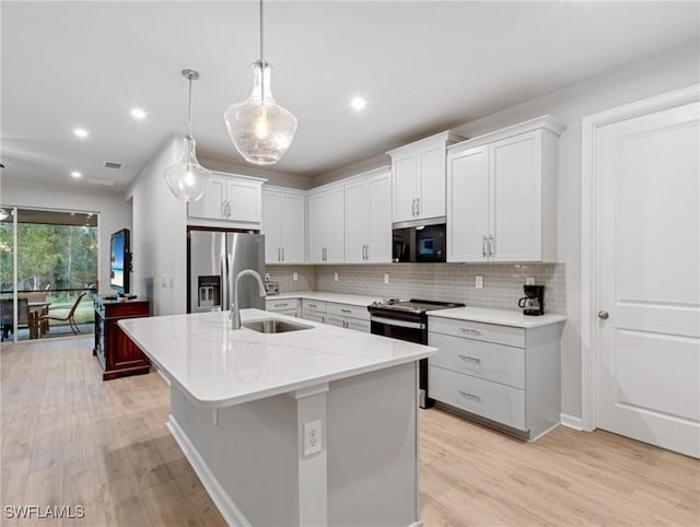 kitchen with sink, white cabinetry, stainless steel fridge, and electric range