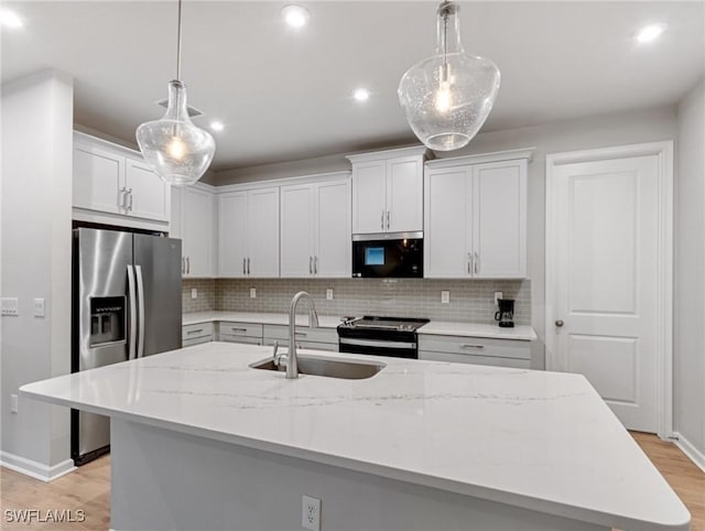 kitchen featuring white cabinetry, pendant lighting, and stainless steel appliances