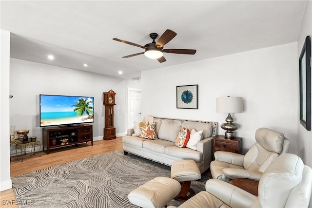 living room with ceiling fan and light hardwood / wood-style flooring