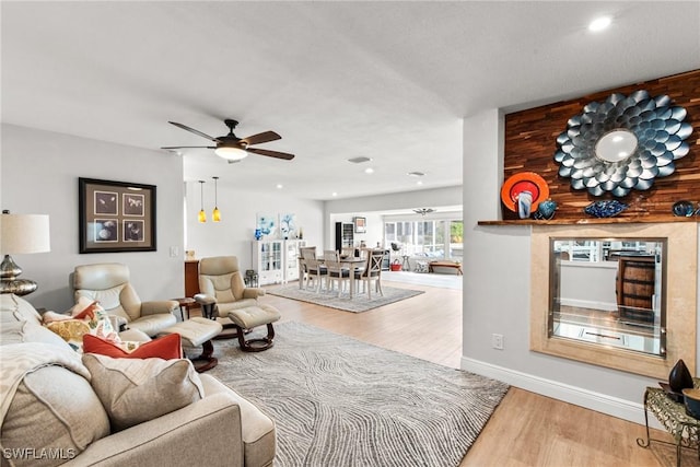 living room featuring ceiling fan and hardwood / wood-style floors