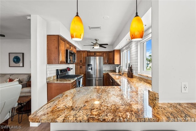 kitchen with backsplash, appliances with stainless steel finishes, and kitchen peninsula