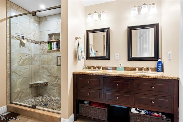 bathroom featuring a shower with shower door and vanity