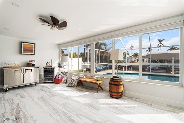 sunroom / solarium featuring ceiling fan and a healthy amount of sunlight