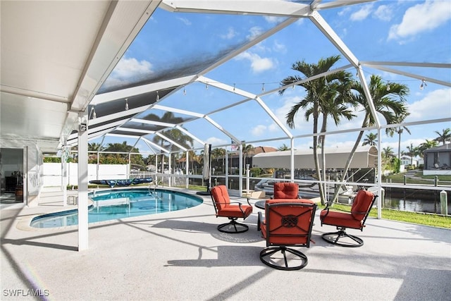 view of swimming pool featuring a water view, glass enclosure, and a patio area