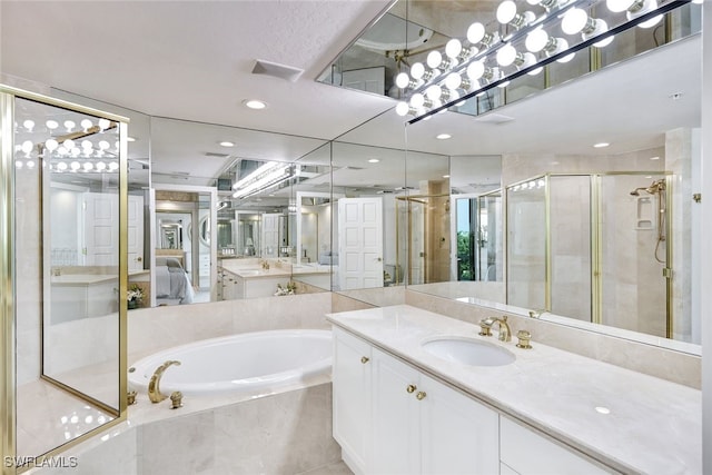 bathroom with vanity and shower with separate bathtub