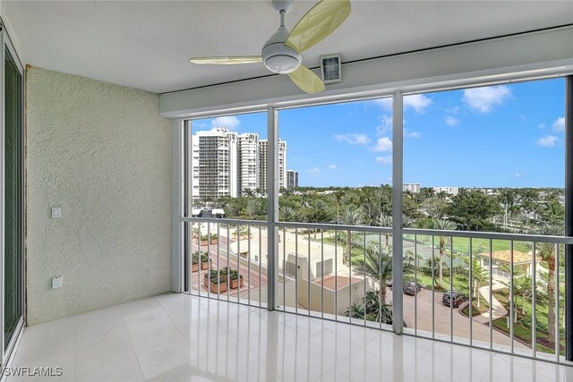 unfurnished sunroom featuring ceiling fan