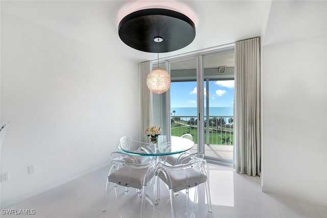 dining space with floor to ceiling windows, light tile patterned floors, and a water view