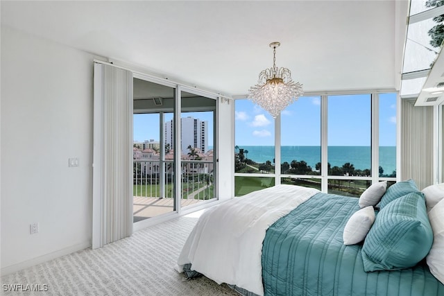 carpeted bedroom featuring access to outside, a water view, an inviting chandelier, and expansive windows