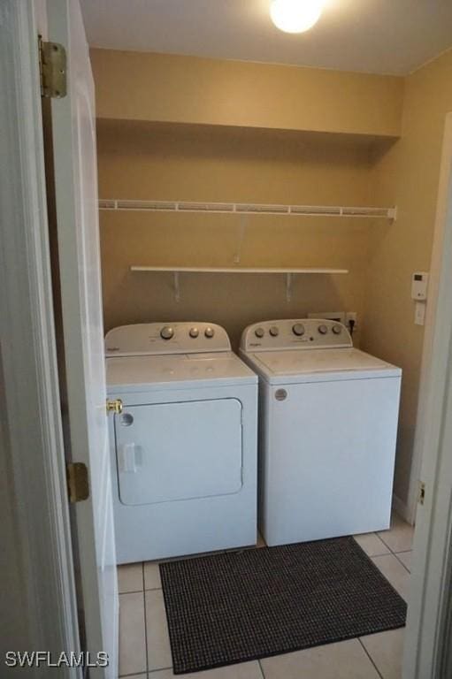 washroom with washing machine and dryer and light tile patterned floors