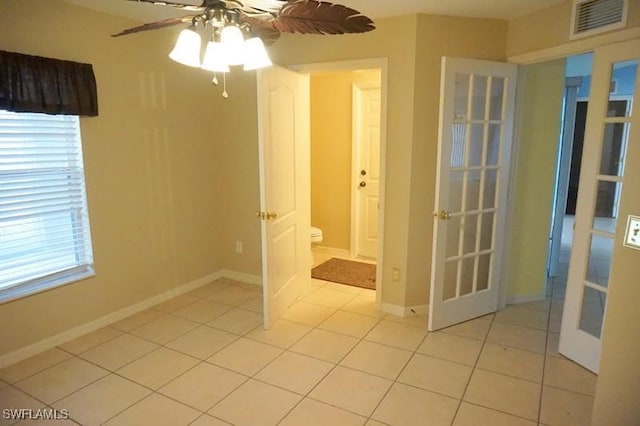 tiled empty room with ceiling fan