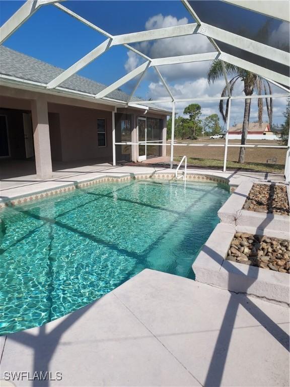 view of swimming pool with a patio and glass enclosure