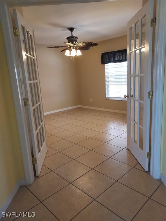 unfurnished room with french doors, ceiling fan, and light tile patterned floors